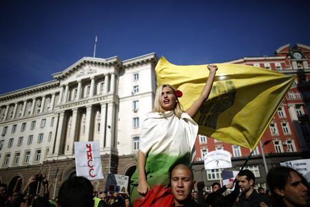 Protester wrapped in Bulgarian national flag shouts anti-government slogans in front of the government building in central Sofia